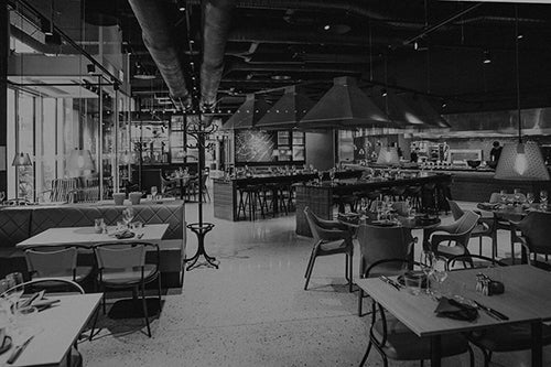 A restaurant dining room being set up and ready for customers.