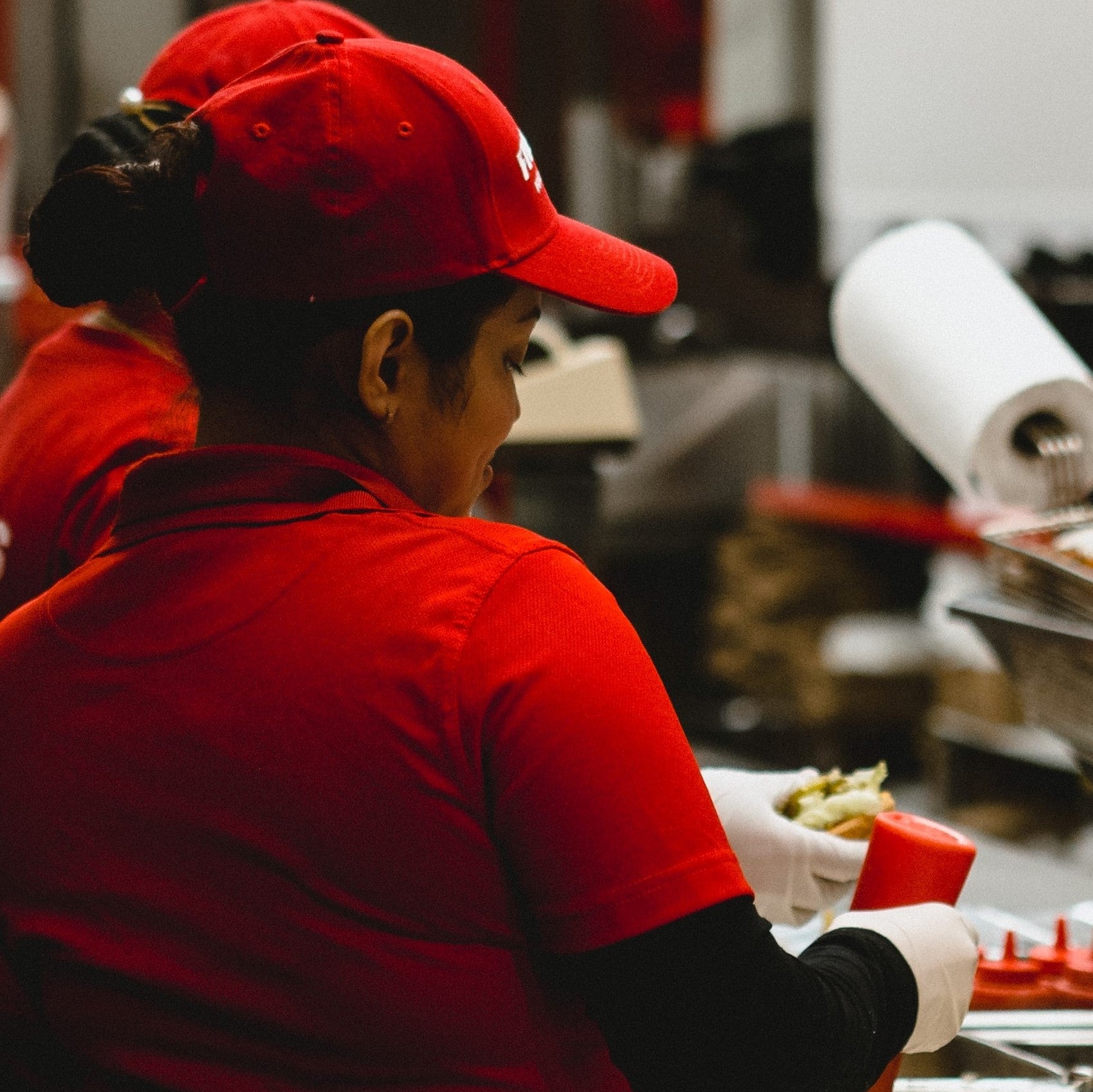 Quick service restaurant employee preparing food.