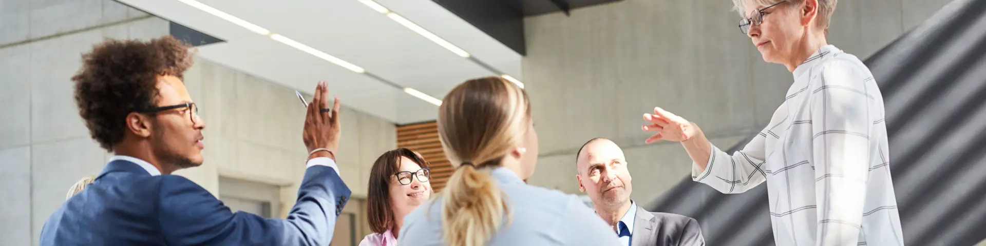 A group of employees discussing solutions around a conference table in an open office.