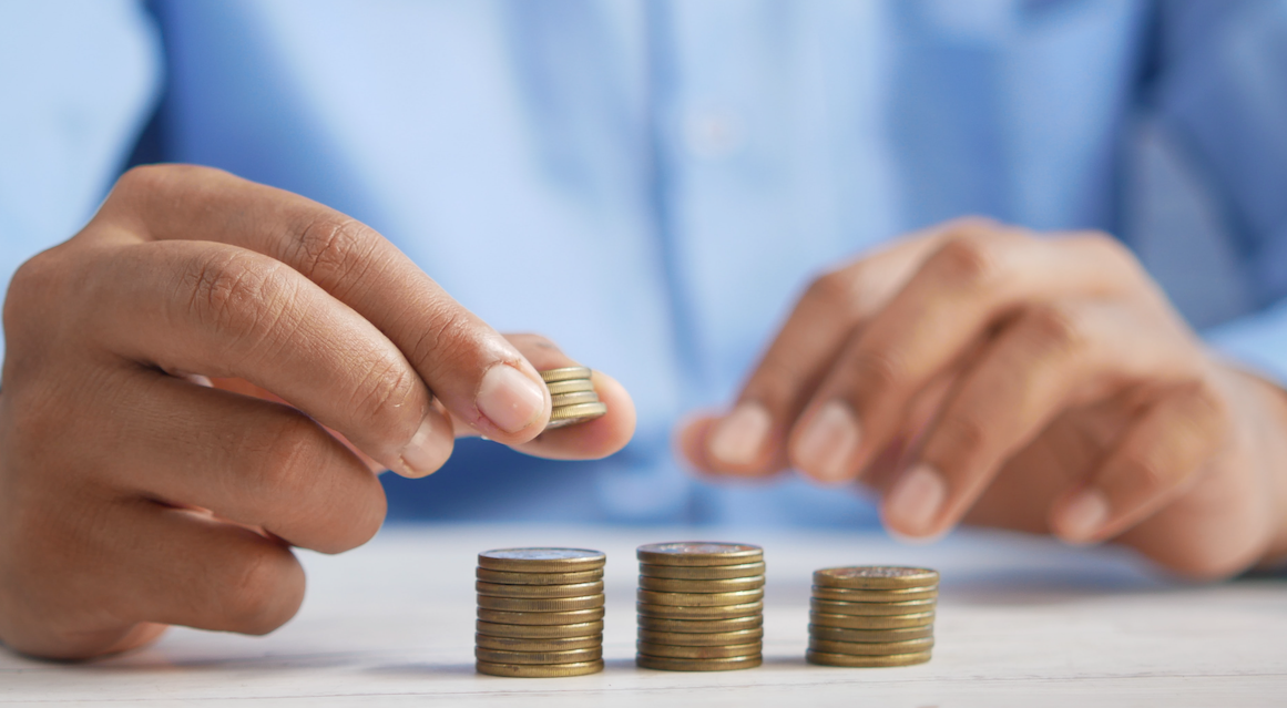 Person stacking coins. 