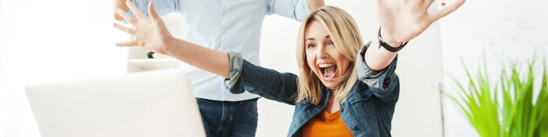 Woman excited in front of laptop