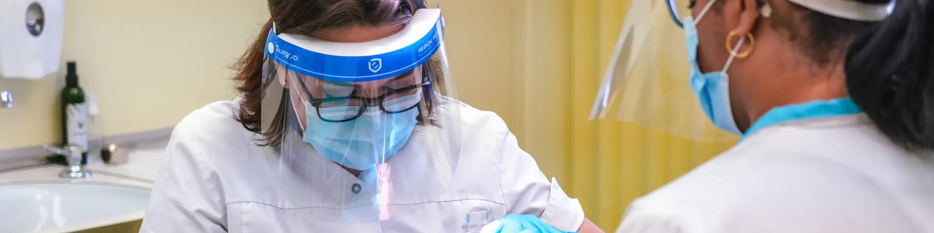 Two medical professionals performing a routine check-up on a patient.