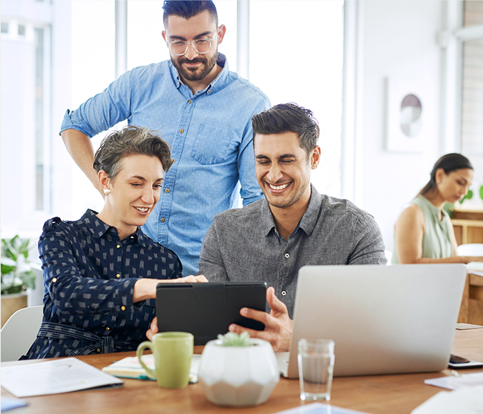 Group of three coworkers working together on a tablet