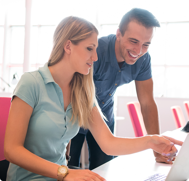 Two office workers looking at a computer