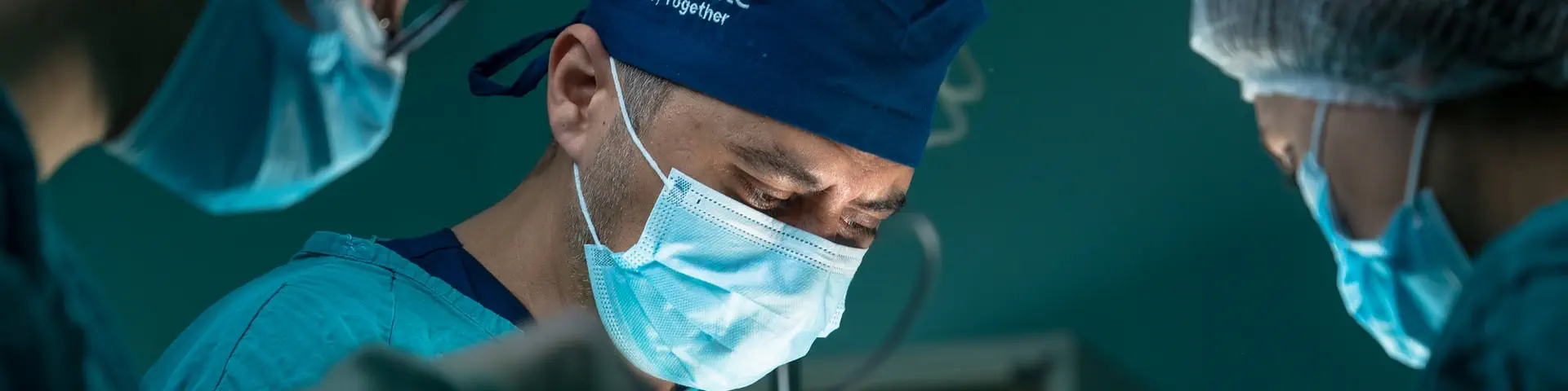 A group of doctors and nurses perform a delicate operation on a patient.