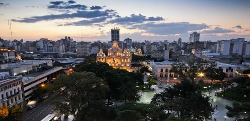 Centro histórico de Córdoba Capital iluminado al atardecer, con la Catedral y la plaza principal al frente.