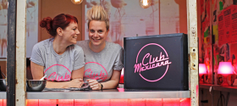 Two women standing, smiling behind the counter at Club Mexicana.