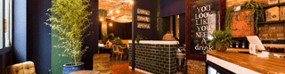The inside of 21 Soho, with plants and decor and warm lighting.