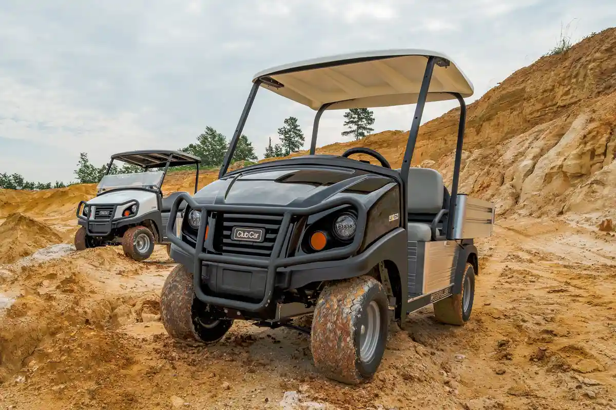 Club Car Carryall vehicles on a rocky dirt path
