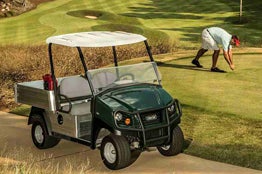 A Club Car Carryall 500 turf utility vehicle is parked next to the green.