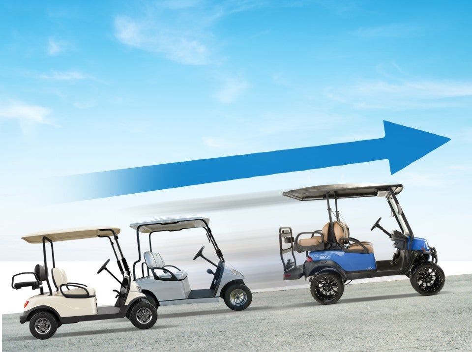 Two golf carts climb a hill. 