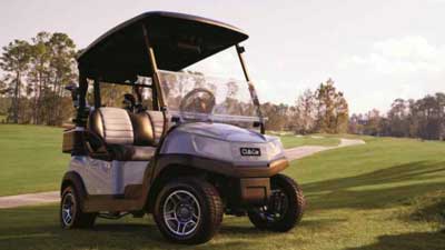 A Club Car golf cart is parked outside on a golf course.