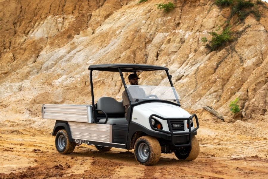 A man drives a Carryall 700 in a rough terrain.