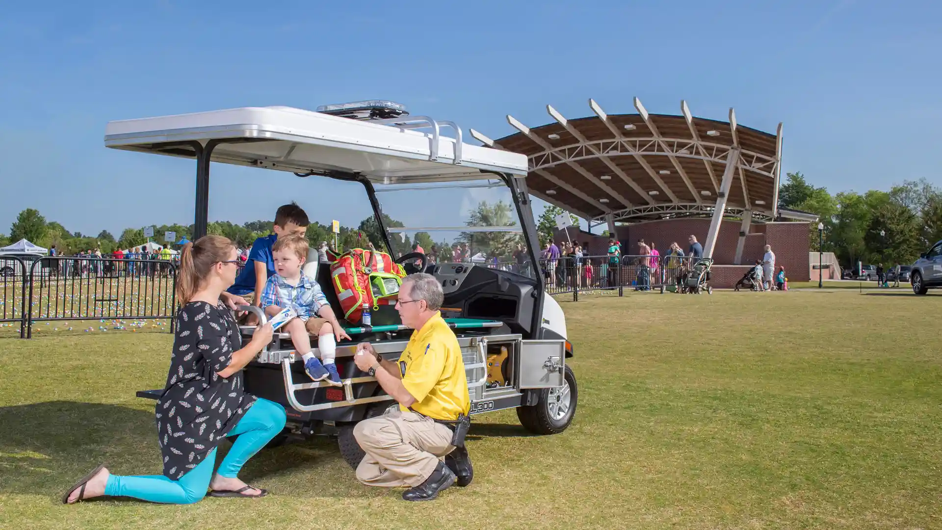 A family speaks with a paramedic while sitting on a Carryall 300 outfitted with medical accessories. 