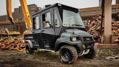 A commercial 4x4 Club Car is parked next to a construction site.