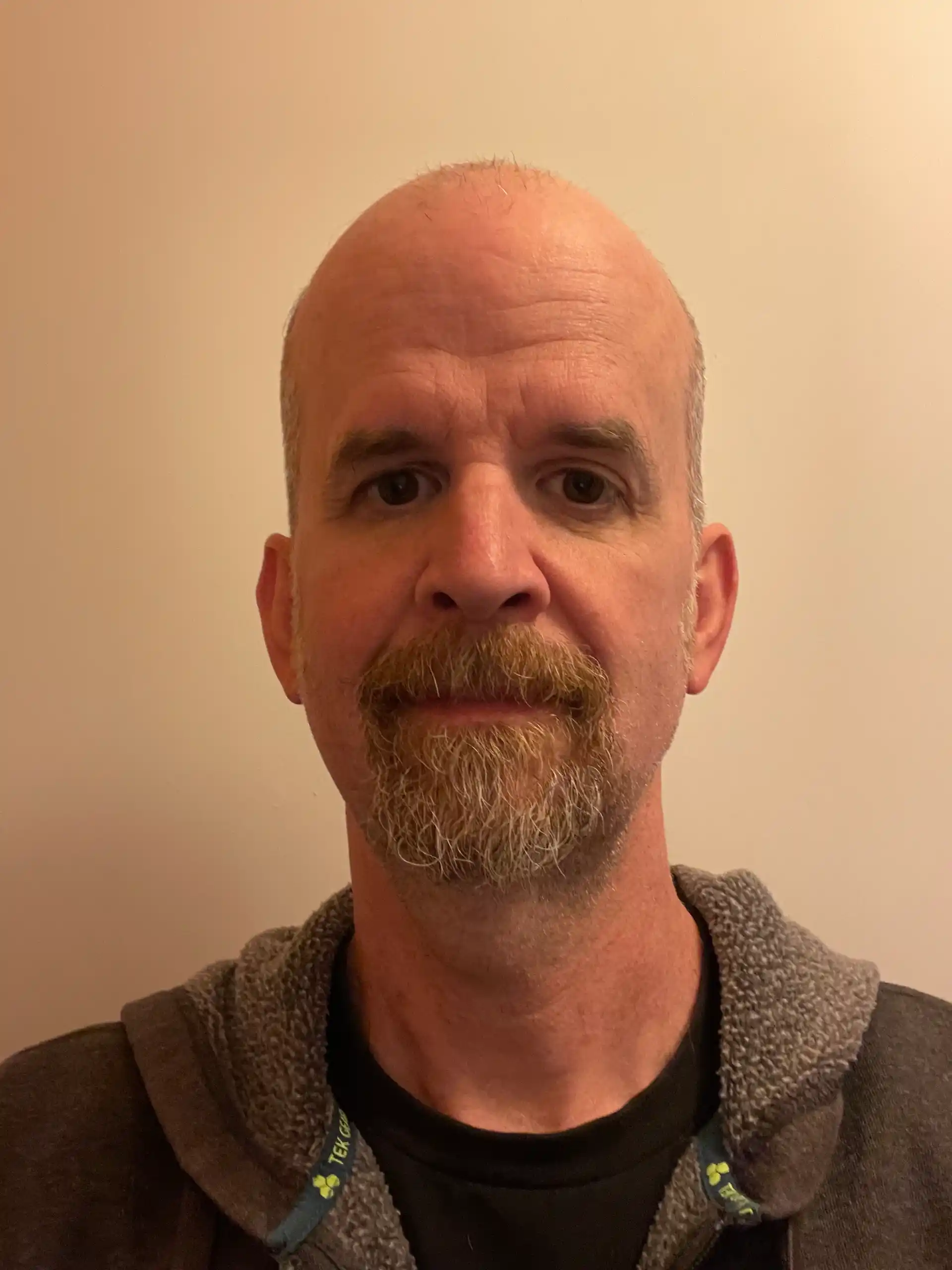 profile photo of a man with a beard wearing dark green