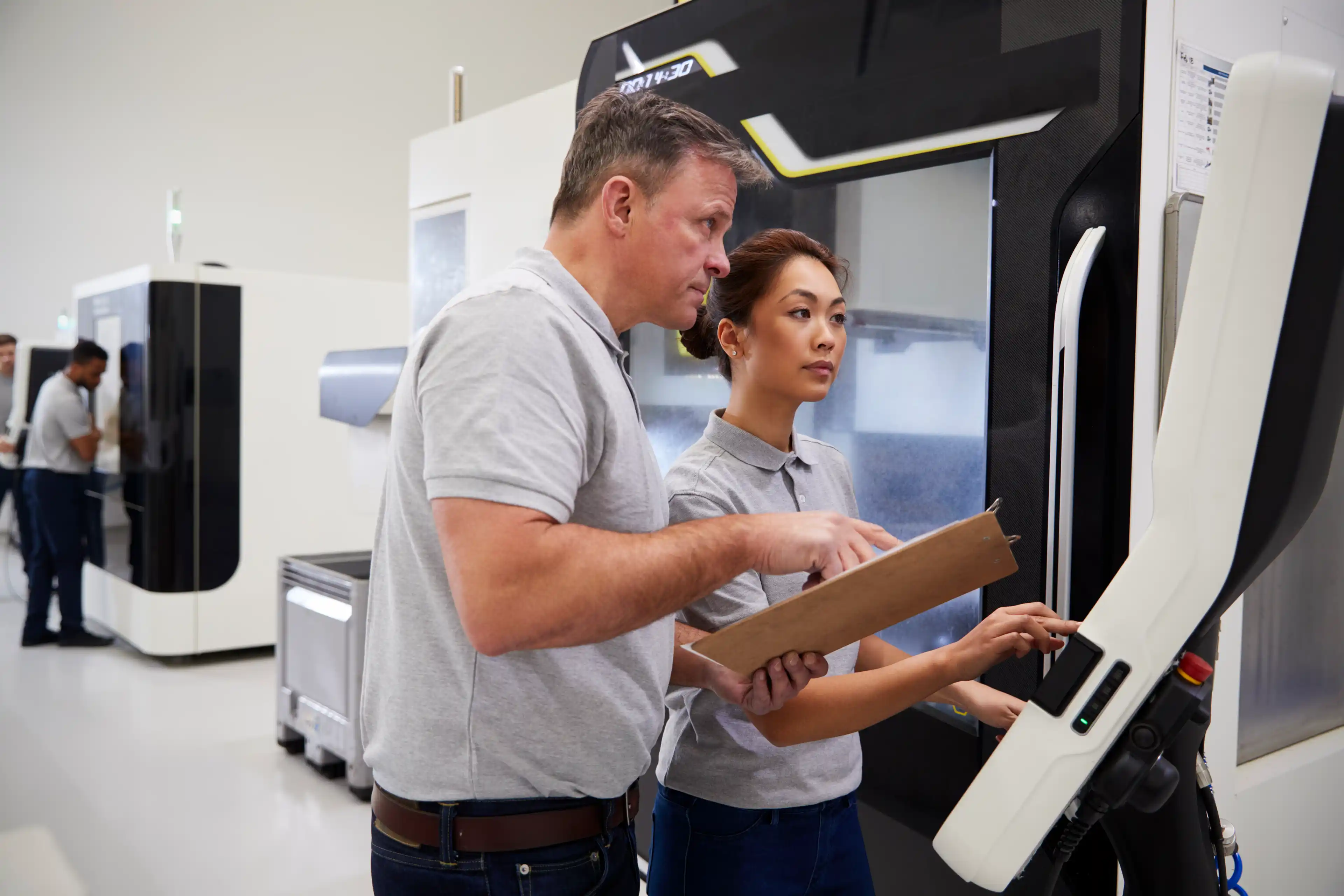 Engineer Training Female Apprentice To Use CNC Machine In Factory