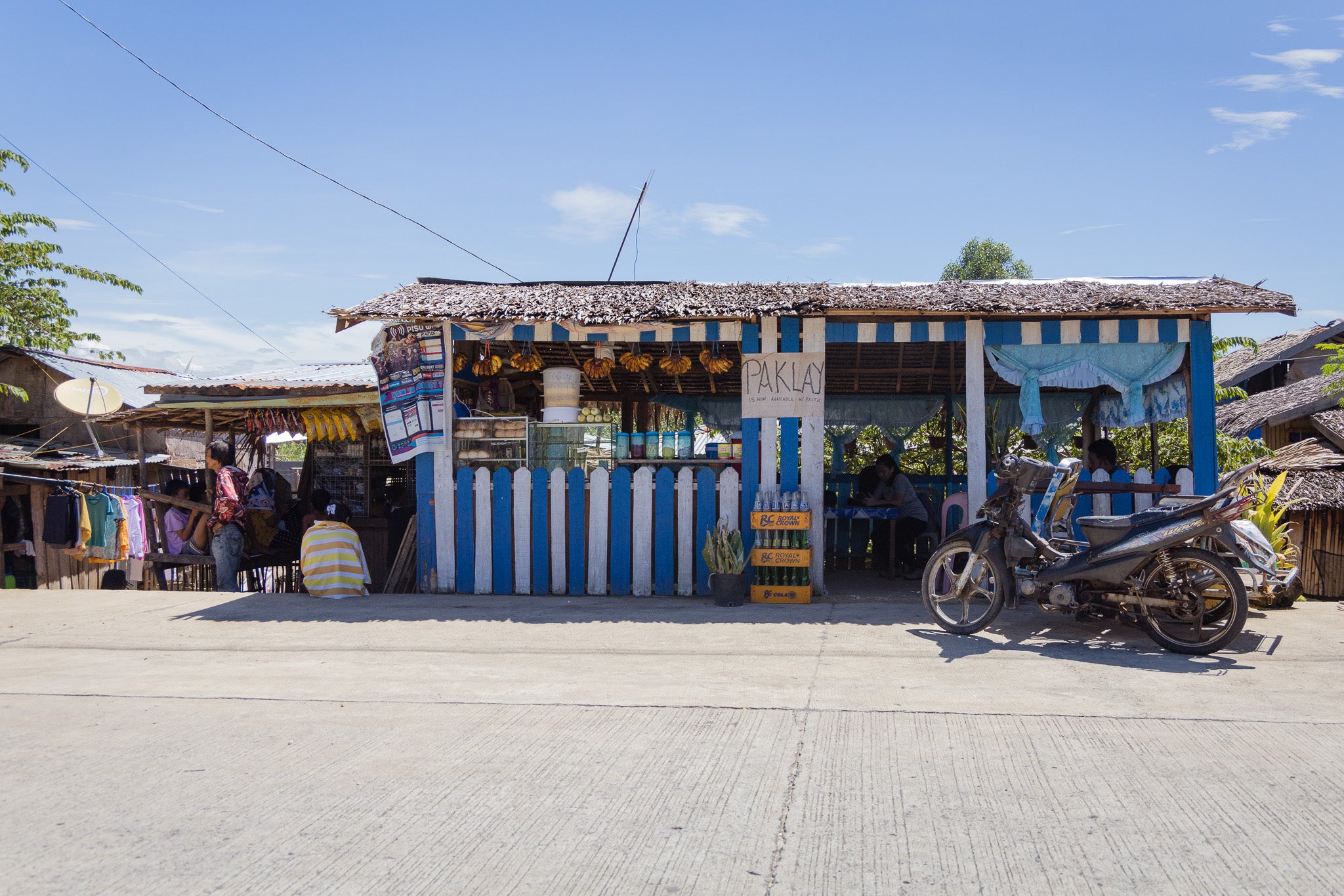 An outdoor front view of a blue and white painted shop in the Philippines.