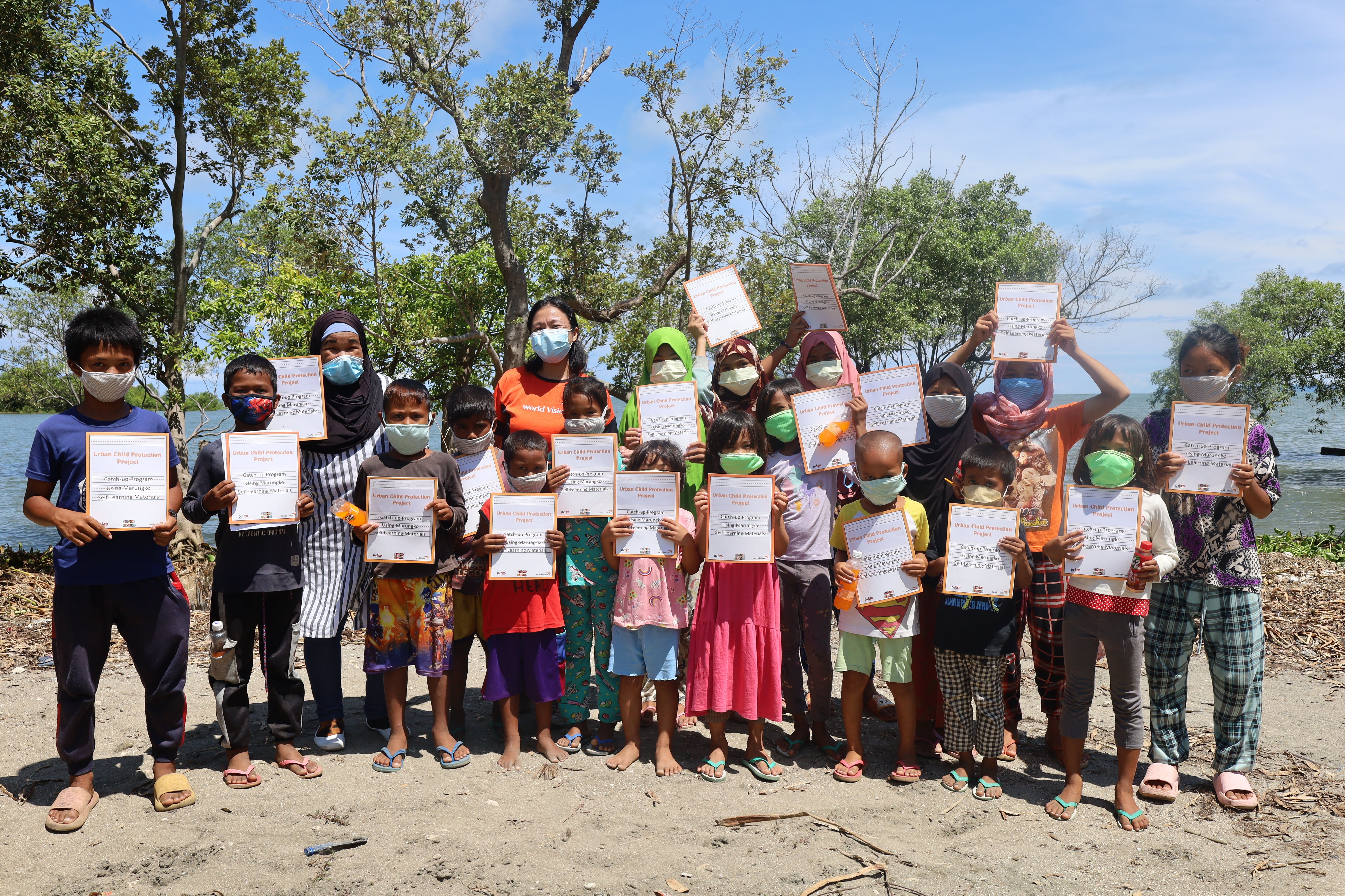 A group of children proudly pose with their Summer Reading Club completion certificates. 