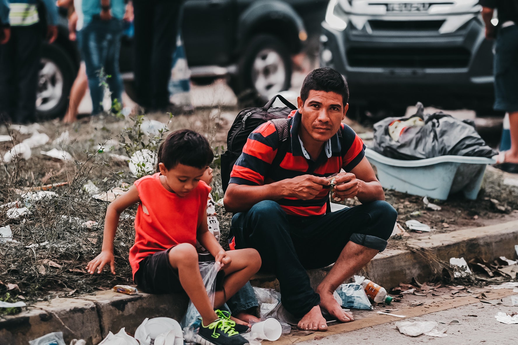 Man & child sit on street