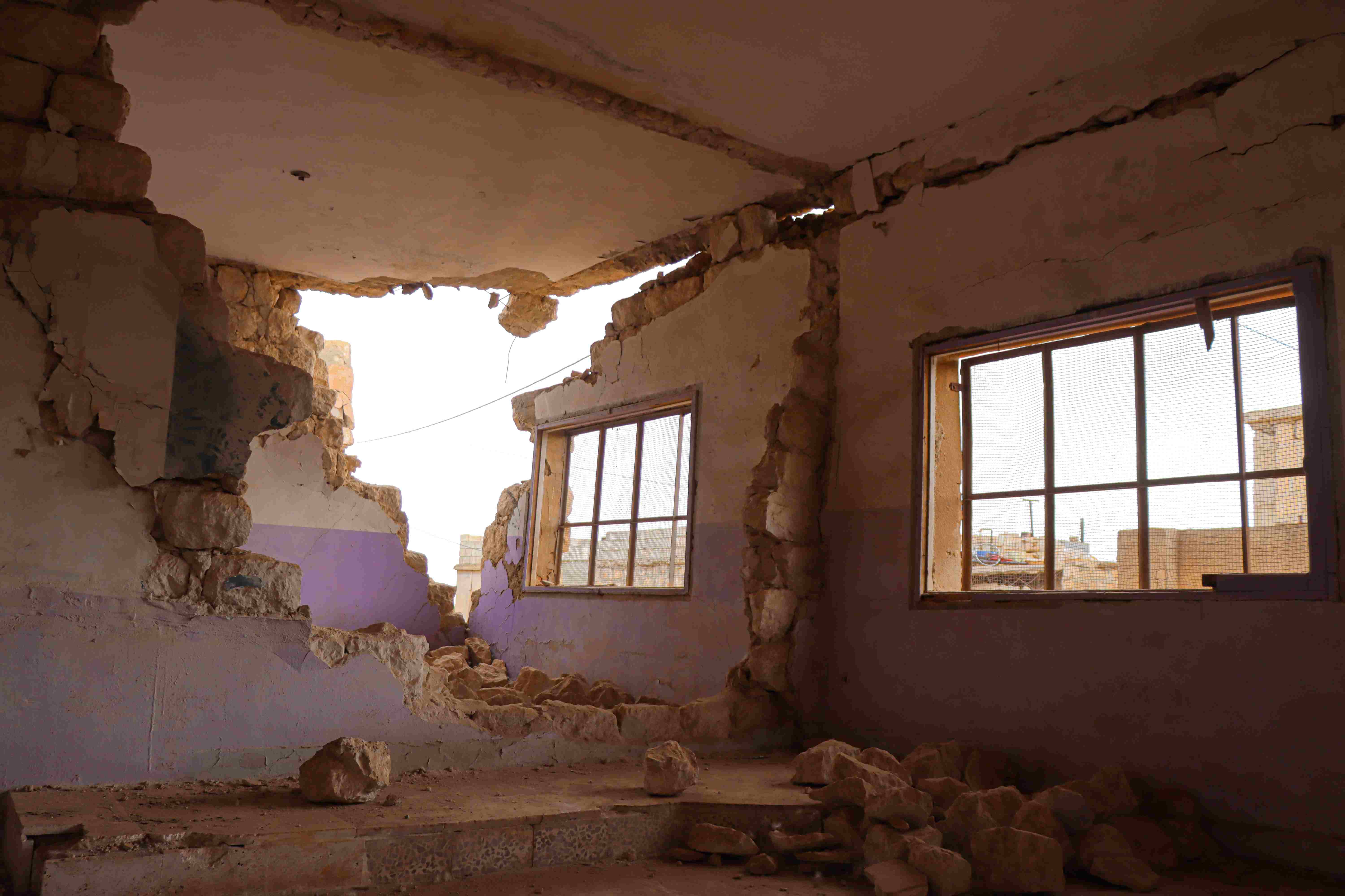 In Syria, a school is damaged by the earthquake. A picture from the inside of the school shows a crumbled interior and exterior wall. 