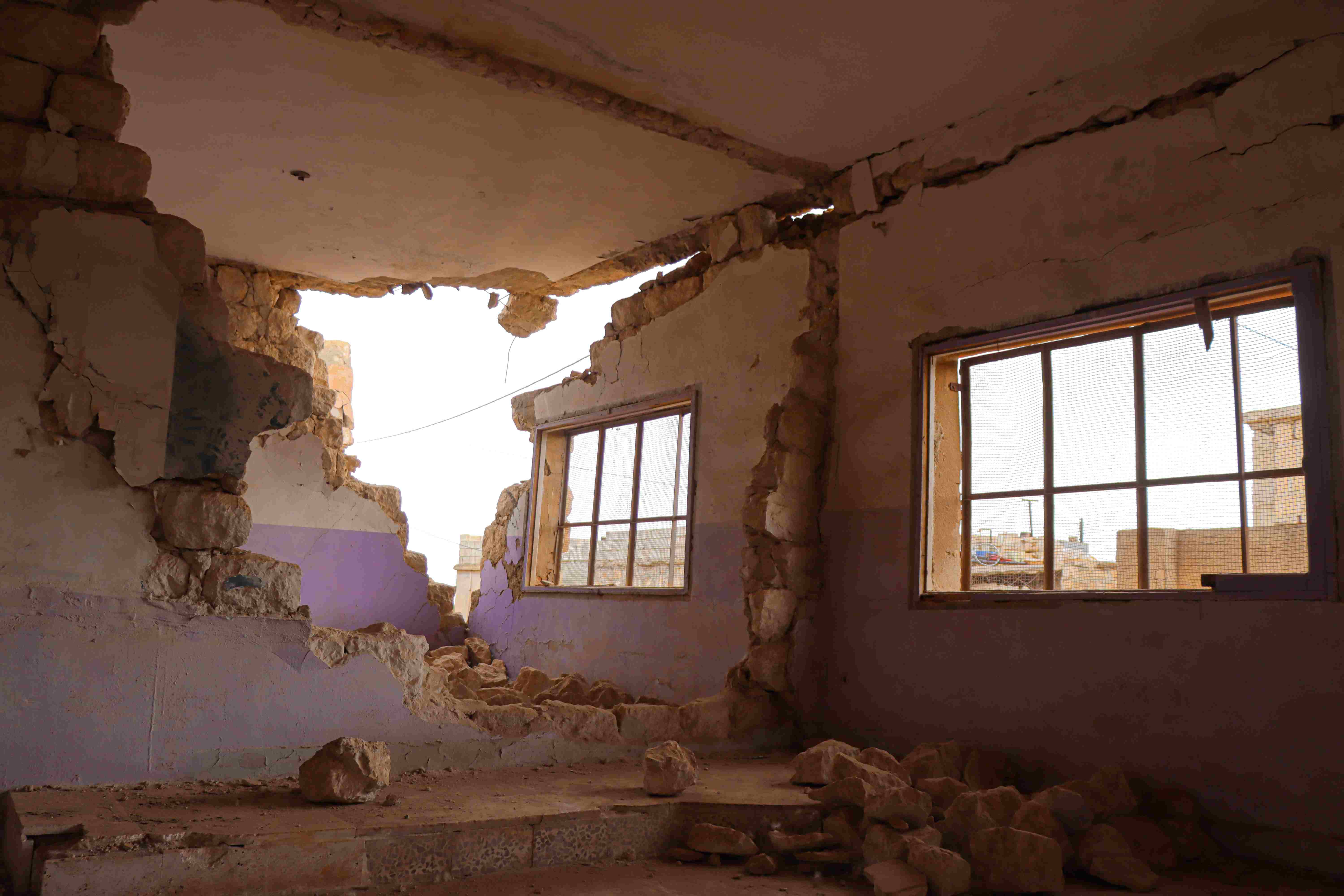 In Syria, a school is damaged by the earthquake. A picture from the inside of the school shows a crumbled interior and exterior wall.