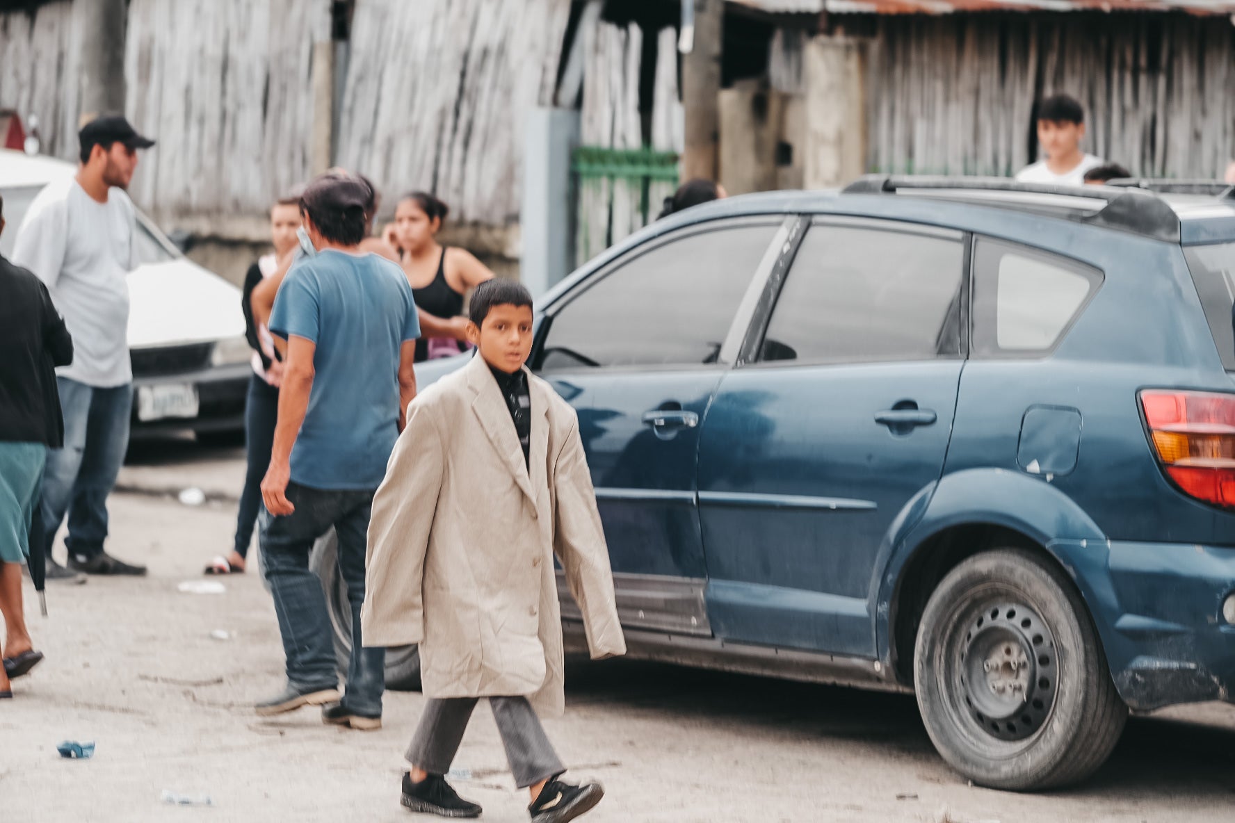 Little boy walks wearing a large adult jacket