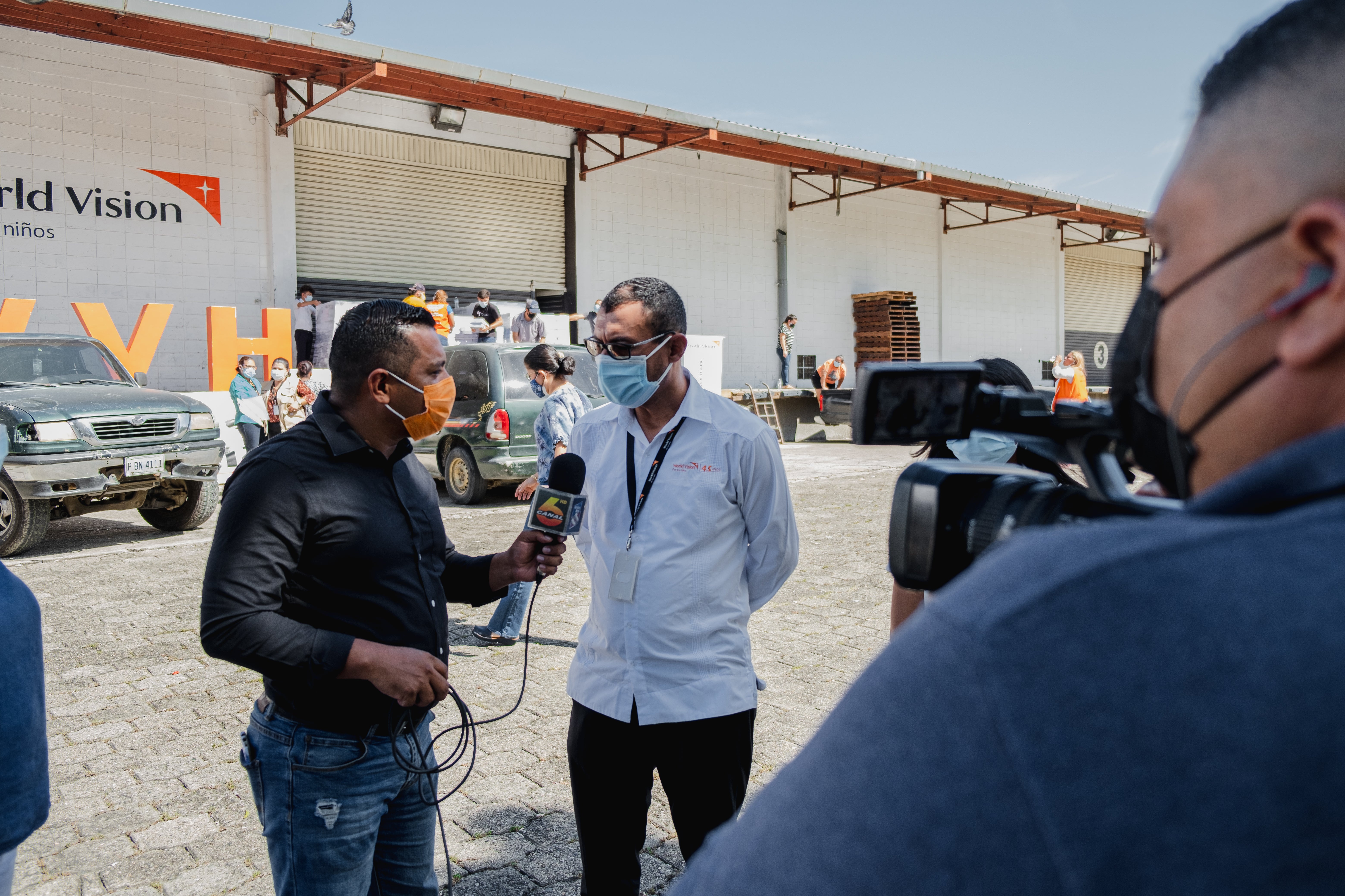 A news anchor interviews the Raw Hope Operations Manager outside World Vision Honduras warehouse.