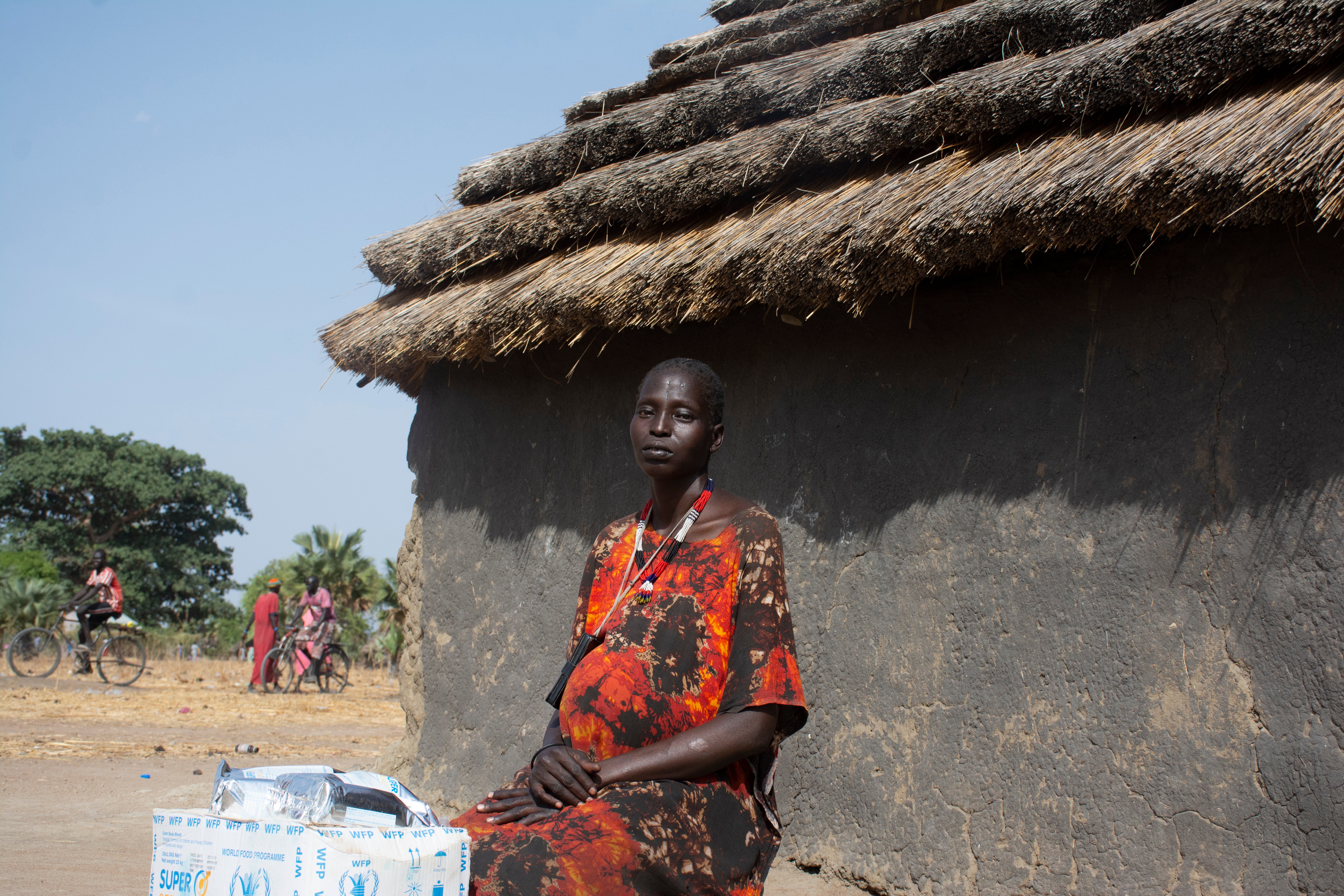 A woman sitting outside of a cabin.