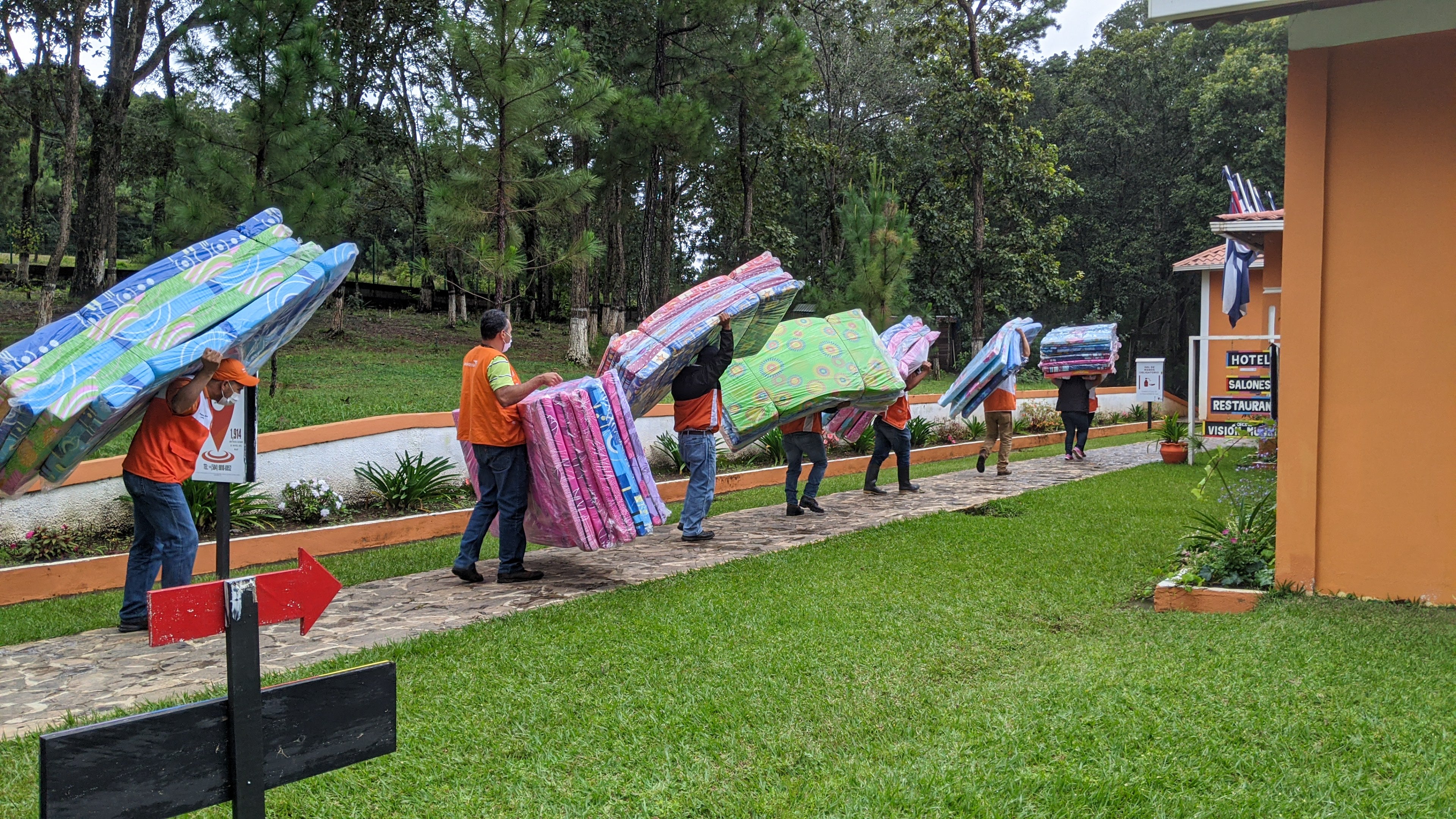 Staff & volunteers distribute mattresses, ensuring children are not sleeping on the ground