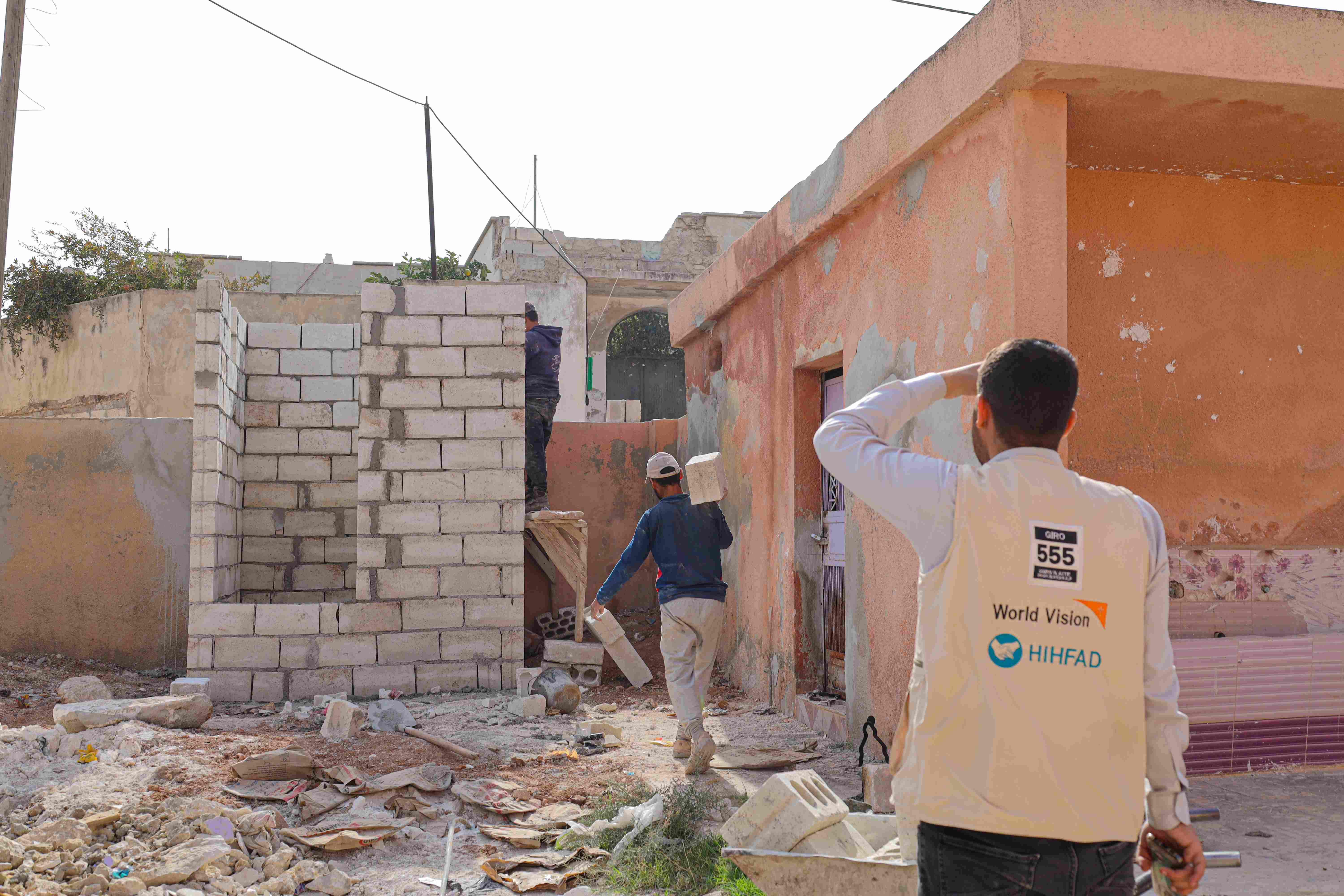 In Syria, a man wearing a World Vision vest oversees new construction being done for the schools. 