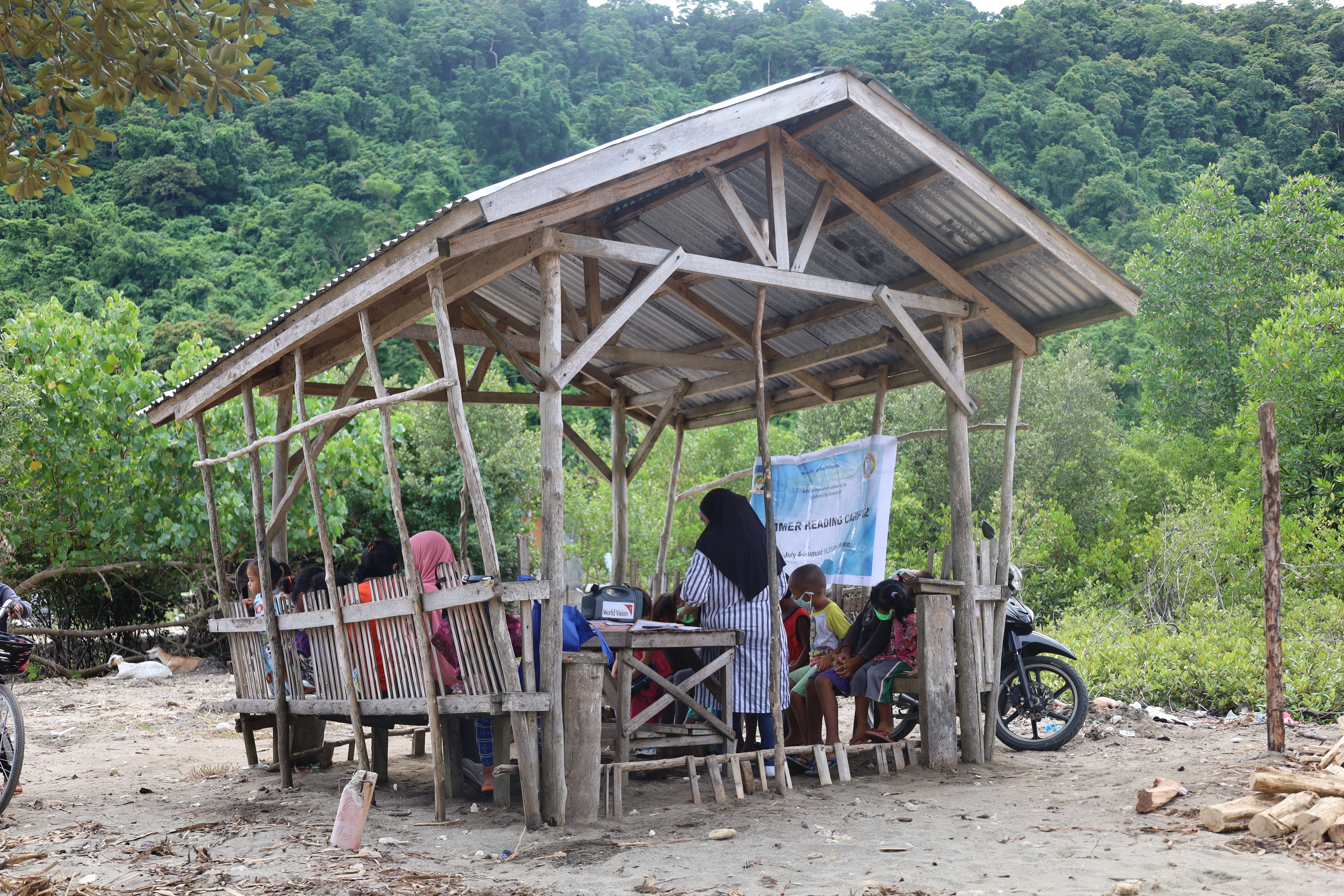 A teacher leads a class of young children in an outdoor learning space.