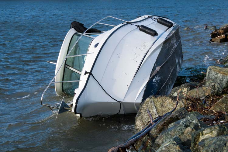 Lone white boat lying on its side on the water. Who's responsible if renters totaled my boat?