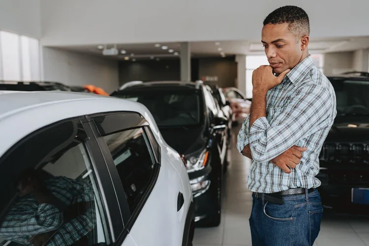 Man analyzing car to buy. Insurance Rate Hikes: Why Auto Insurance Costs Are Rising.