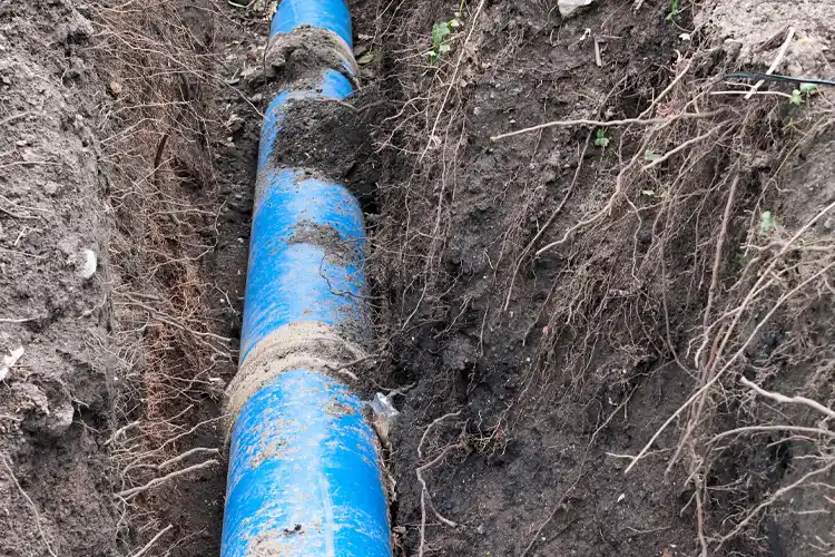 A deep trench dug in the ground to for a large plastic pipeline. Who Pays for Busted Sewage Lines in Kentucky?