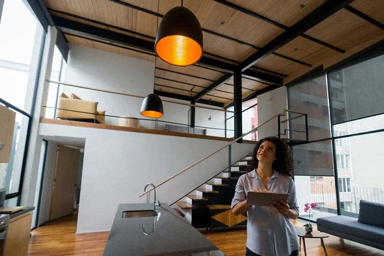 Woman controlling the lights of her house using a home automation system. Smart Home, Smart Car, Smart Everything. 