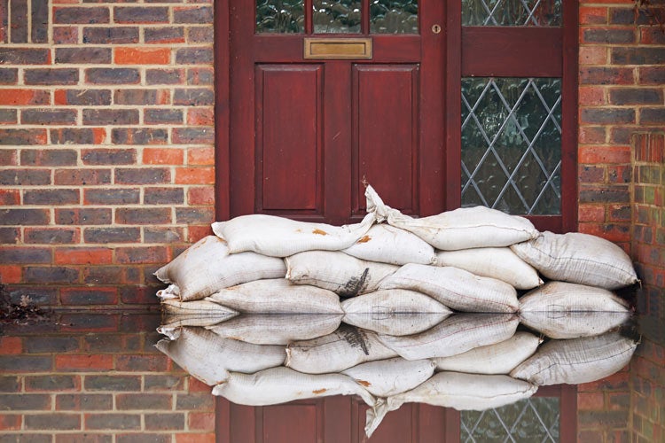 Sandbags Outside Front Door Of Flooded House. Does home insurance cover basement floods in Tennessee.
