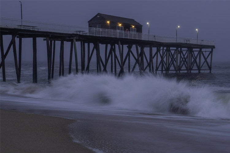 Waves during moody sunrise at Belmar fishing pier in New Jersey as hurricane approaches