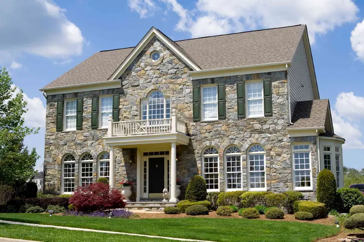 Suburban Front Stone Faced Single Family Home. How Does Home Insurance Factor Into Overall Home Ownership Costs?