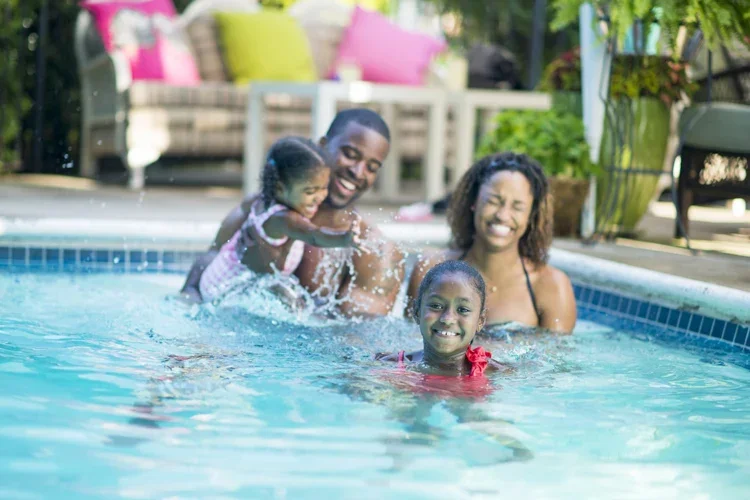 Family having fun in their new pool. From Pool Umbrellas to an Umbrella Policy.
