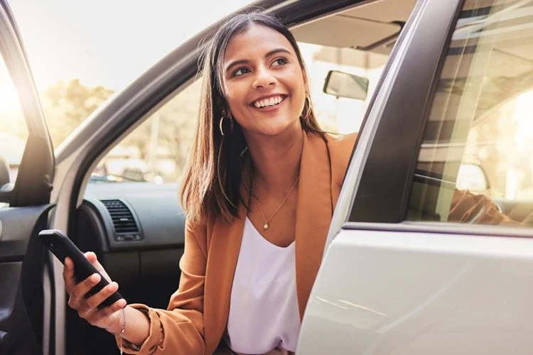 Woman in a car with a phone. Does Car Insurance Follow the Driver or the Car?