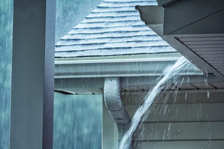 Drenching Rain Storm Water Overflowing Roof Gutter. Does home insurance cover messy basement floods?