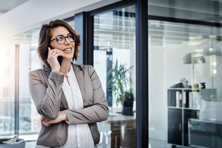 Businesswoman using a smartphone in a modern office. Best insurance companies in Illinois. 