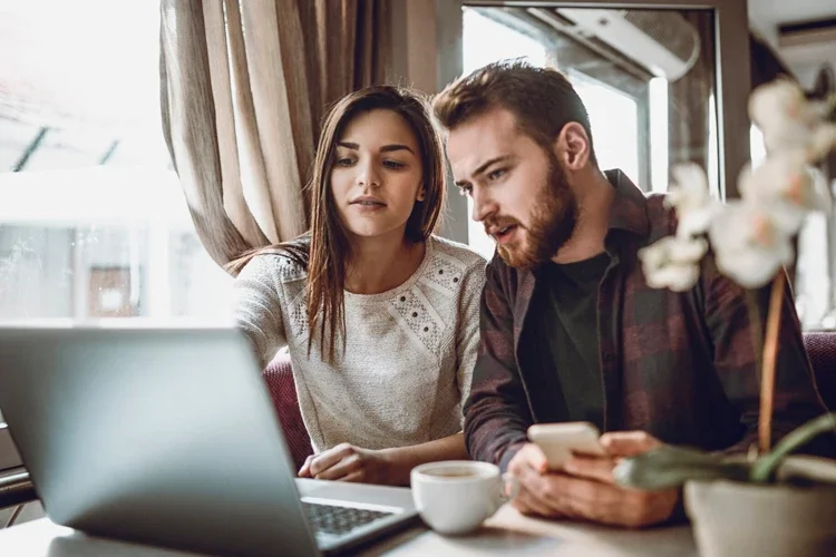 Couple Drinking Coffee and Researching Online. Insurance Myths Busted: What Online Quotes Don’t Tell You.