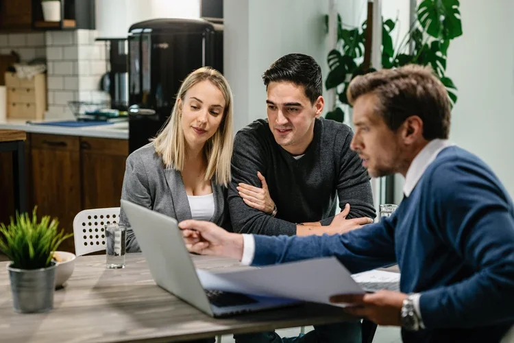 Couple with their investment agent in a meeting. Understanding Insurance: What Is a Hard Market?