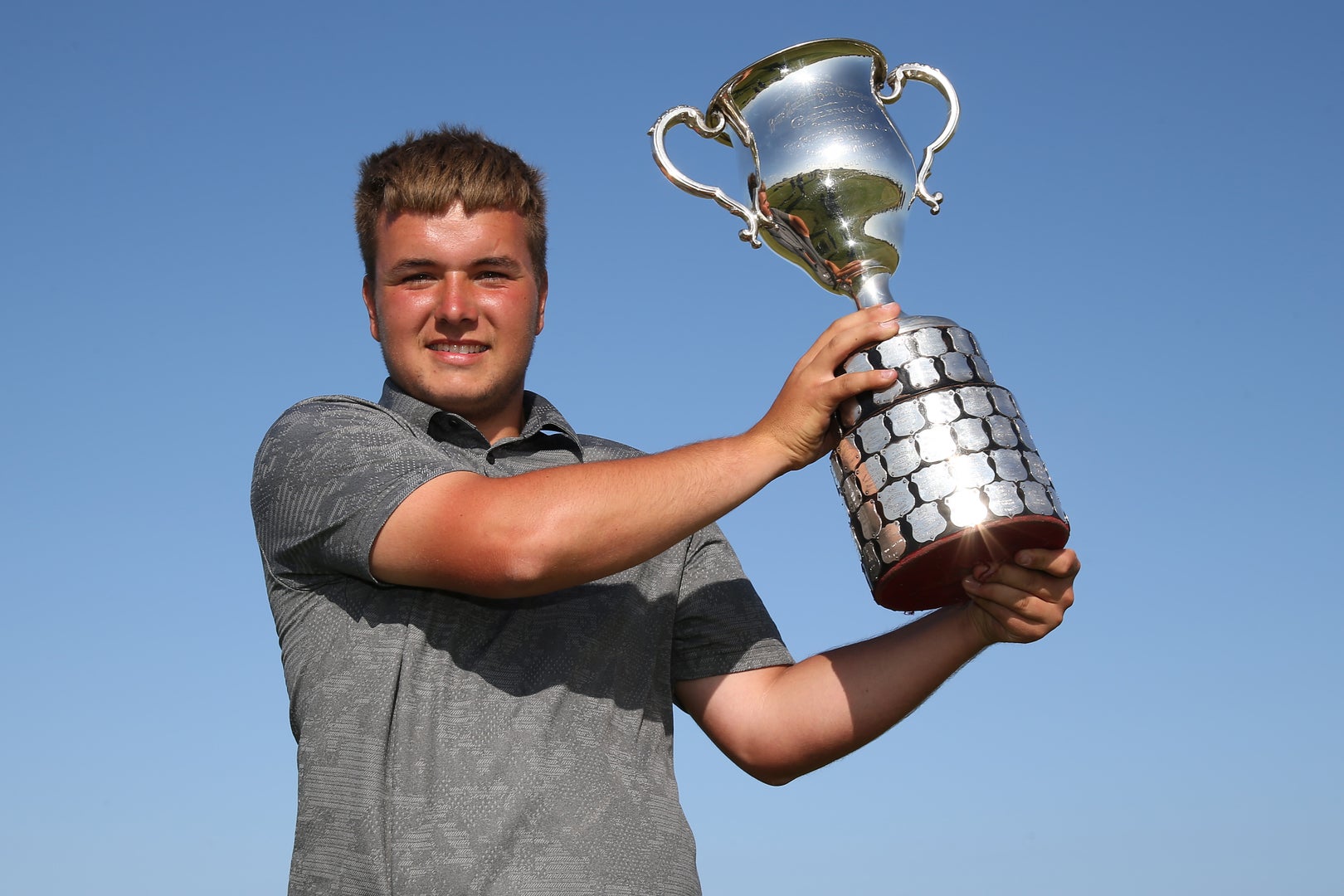 Golfer lifts up trophy