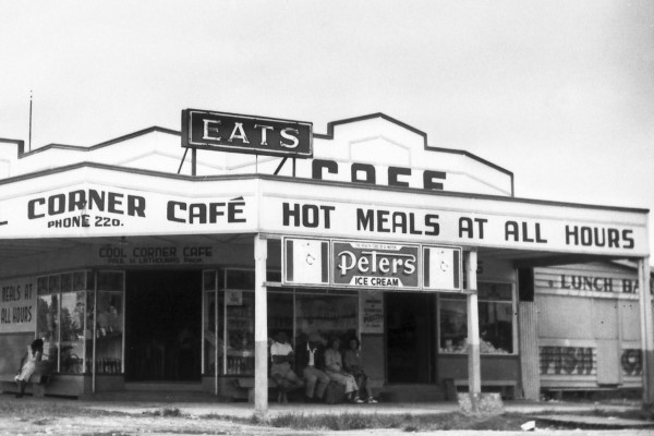 Cool Corner Cafe, corner of King Street and Cotton Tree Parade, Cotton Tree, ca 1945. Built by Albert John Foster, a Cooloolabin saw miller and timber merchant, who moved to Maroochydore in 1937. The cafe was located opposite the Cotton Tree Caravan Park and was named after the 'cool sea breeze' at Cotton Tree locality. The cafe also sold groceries and camping supplies. In 1962 the business was taken over by Doug and Doris MacLeod, who extensively renovated the building and redesigned it based on an America-style cafe. Renamed the Cotton Tree Inn, the new premises included a fish and chip shop, a snack bar, eat-in cafe and restaurant and also sold fresh seafood. The building was destroyed by fire in 1977.