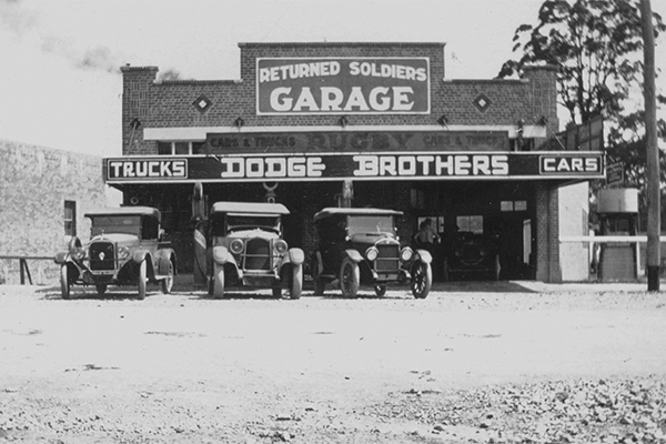 Returned Soldiers' Garage, Currie Street, Nambour, ca 1927. Established in 1919 by Edward Aspland. In1924 Edgar Wells joined the business. He was a fellow returned soldier from World War I. The first petrol bowsers were installed in December 1923. On March 31, 1926, the garage was destroyed by fire along with eight other business premises in Currie Street. A new brick garage (pictured) was opened on the site in October 1926.
