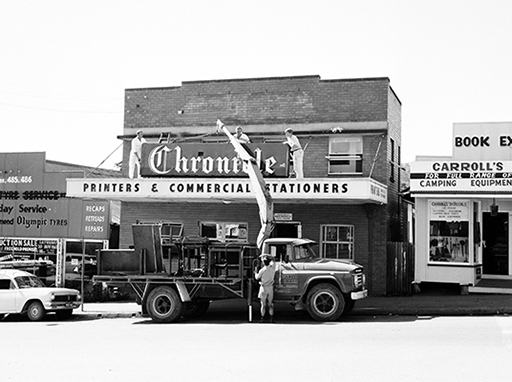 Removing the sign from the Nambour Chronicle office at the northern end of Currie Street, Nambour. The Company relocated the sign, along with its printing plant to a new building in Price Street, Nambour, where it began printing on 23 May 1966.