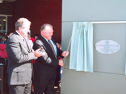 Caloundra City Council Mayor Don Aldous applauds as Des Dwyer unveils the plaque at the official opening of Des Dwyer Beerwah and District Library on 28 June, 2000.